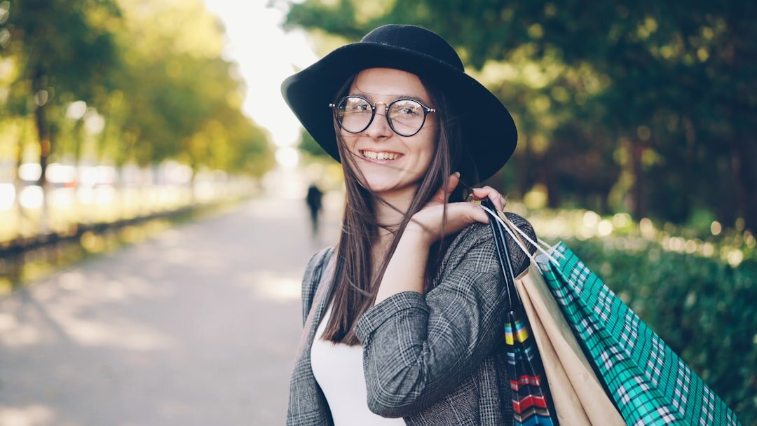 Smiling woman with shopping bags in park
